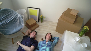 一对年轻夫妇躺在公寓的地板上休息33秒视频
