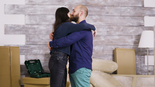 幸福的年轻夫妇在新公寓里拥抱彼此视频