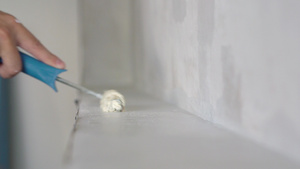 房子里的装修用带有白色油漆的滚筒画一堵白墙12秒视频