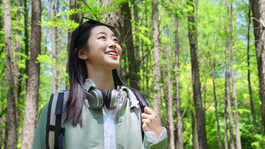 户外美女在森林公园用相机拍摄美景视频