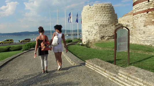 旅游者、母亲和女儿在被毁坏的塔楼附近行走,并在布加里阿古老的内塞巴镇周围筑石墙视频