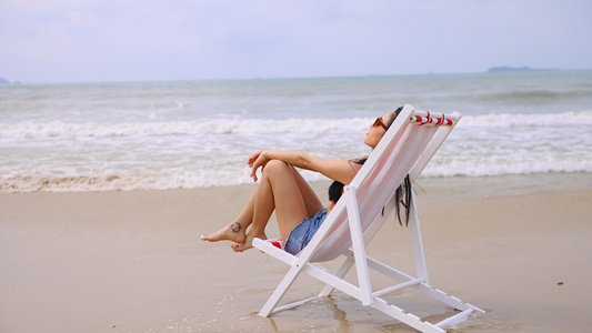 海边沙滩椅上休息的美女视频