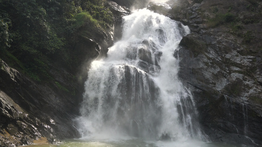 慢动作 Karome 瀑布在泰国。瀑布流淌，落下巨大的黑色石头。热带森林花岗岩山上的瀑布。亚洲茂密的丛林。美丽视频