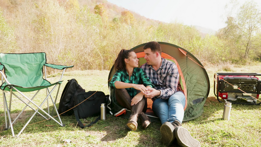 有吸引力的年轻夫妇在舒适的露营地点拥抱视频