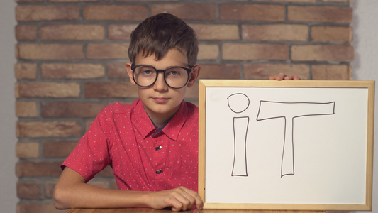孩子坐在桌子上 拿着翻页图 用信写在背景的红砖墙上视频