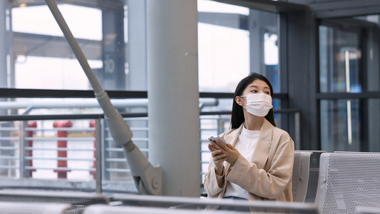 女孩在车站座位上无聊地等待视频