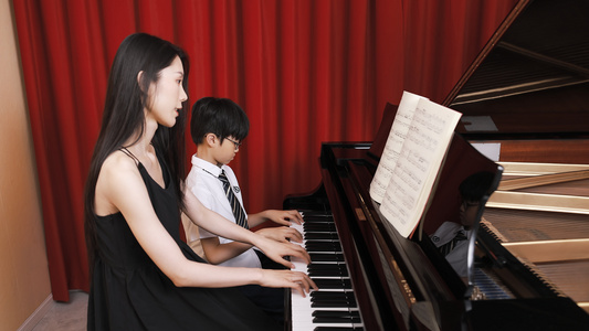 音乐教师教儿童弹奏钢琴看琴谱视频