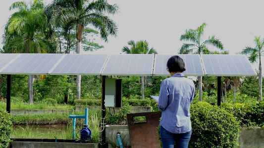 农艺师农民使用平板电脑监控太阳能电池在农场抽水。使用移动应用技术进行农业电力管理视频