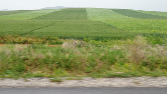 驾驶汽车通过农业田地行驶在公路上视频