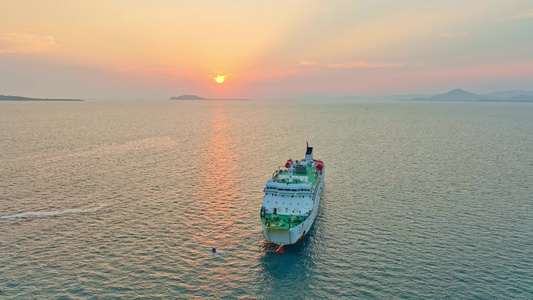 海南三亚橘红色夕阳晚霞下行驶的巨型豪华游艇视频