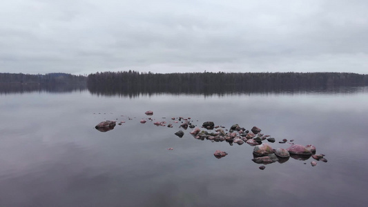 散落在芬兰湖湖空中轨道全景的水域中的石头视频