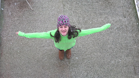 女孩转过身去享受第一次下雪,空中4K射击视频