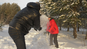 男女在冬季漫步于雪林中时扔雪球21秒视频