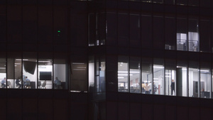 航拍城市夜晚金融互联网公司写字楼灯火通明加班的员工4k素材61秒视频
