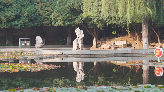 秋天公园游乐场湖泊鱼群和雕像视频