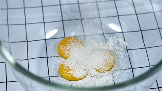 在蛋黄和白砂糖中加入低筋面粉视频