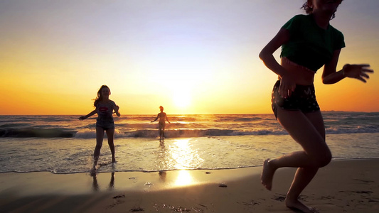 热带海滩日落时,有3个女孩用光了海水,在热带海滩上视频