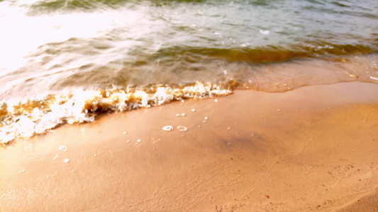 海浪在海滩上的黄沙滩上漂浮视频