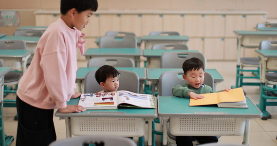 哥哥在教室里教弟弟妹妹看书慢镜头视频