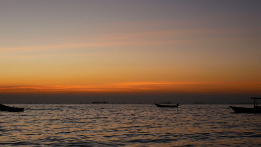 4K。小船在海上的剪影，在日落或日出时有小波，美丽的阳光与水面反射视频