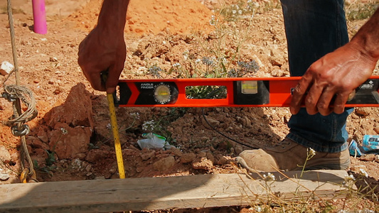 建筑工人用水平仪和卷尺检查建筑工地的孔深视频