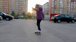 日落时在城市街道上玩滑板的女孩7秒视频