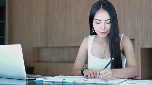 女商人在办公室使用计算机和文档。创业女企业家在工作场所分析财务数据视频