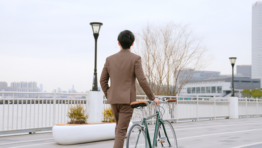 都市男青年在江边推行自行车视频