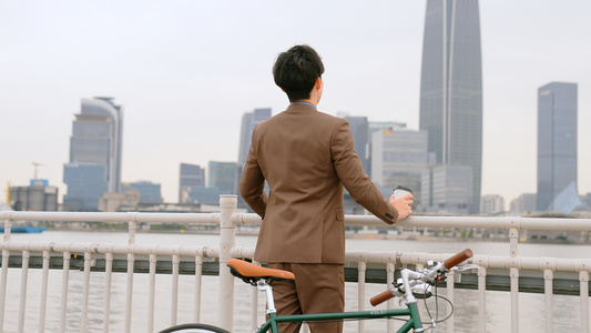 骑单车的都市男青年在江边吹风视频