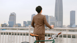骑单车的都市男青年在江边吹风34秒视频