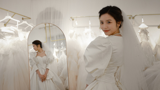 在镜子前试穿婚纱的甜美新娘视频