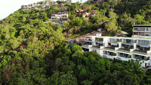 豪华别墅的雄伟无人机视图位于小海滩附近的热带天堂岛上的绿色山脉上47秒视频