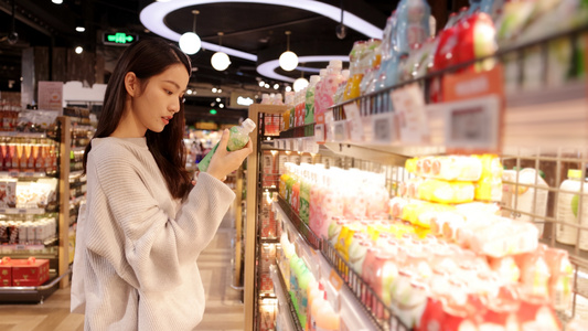 拿着手机挑选饮料的女青年视频