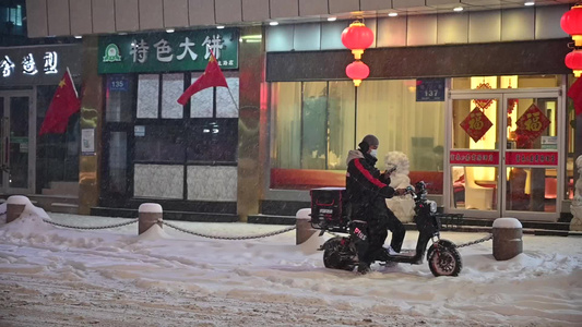 升格拍摄夜晚下雪中城市快递送餐小哥视频
