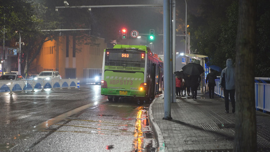 冬日雨夜中等待做公交车的职场上班人视频