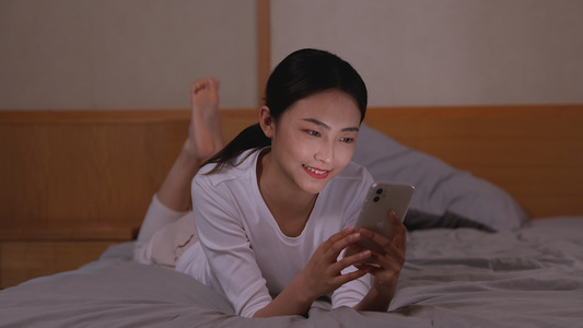 女孩卧室床上轻松玩手机聊天[客卧]视频