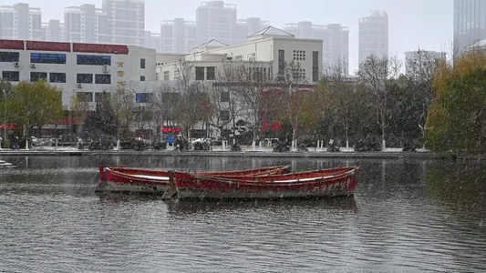 冬天大雪纷飞湖泊上的红船视频