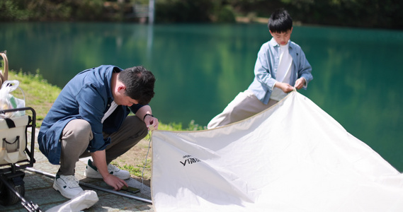 一对父子正在湖边扎帐篷 露营 踏青视频