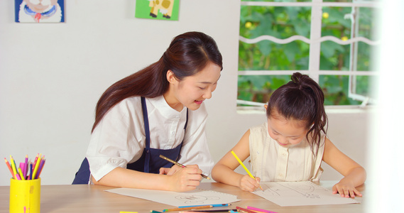 和蔼的青年老师教小女孩画画视频