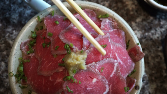 手用筷子在餐厅里吃日本生肉切片的中国人肉视频