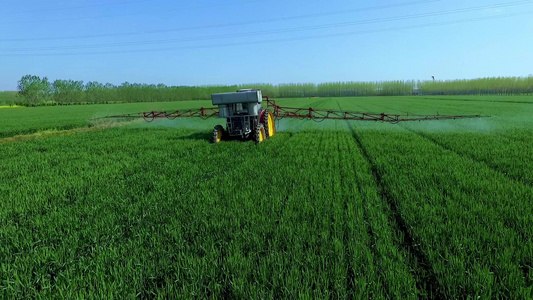 航拍大型农机在麦田植保和施肥视频