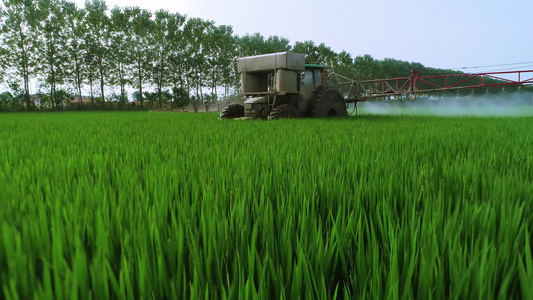 航拍大型农机在麦田植保和施肥视频