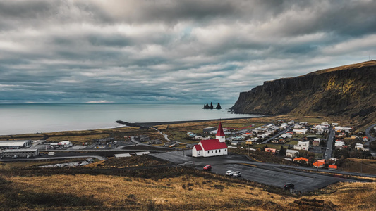 海边教堂荒原乌云密布冰岛红顶教堂延时摄影视频