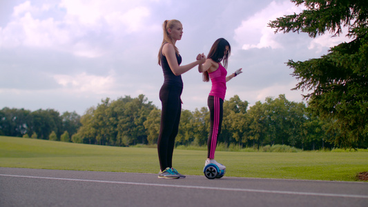 女性在瑜伽教练辅导下练习平衡车视频