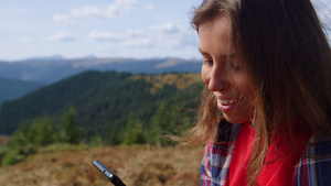 女性在山顶看着手机面带微笑26秒视频