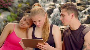 三个年轻人拿着平板电脑聊天分享18秒视频