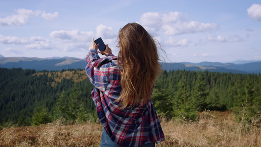 女性登山背包客拍照记录美景视频