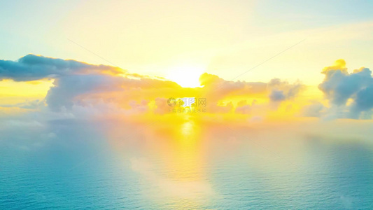 海南文昌海岸线蔚蓝色海洋上的日出云海朝霞耶稣光航拍延时视频