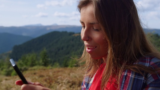 女孩爬到山顶用手机聊天视频