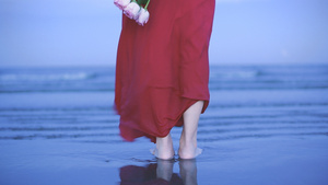 女孩手拿鲜花站在海滩上4K12秒视频